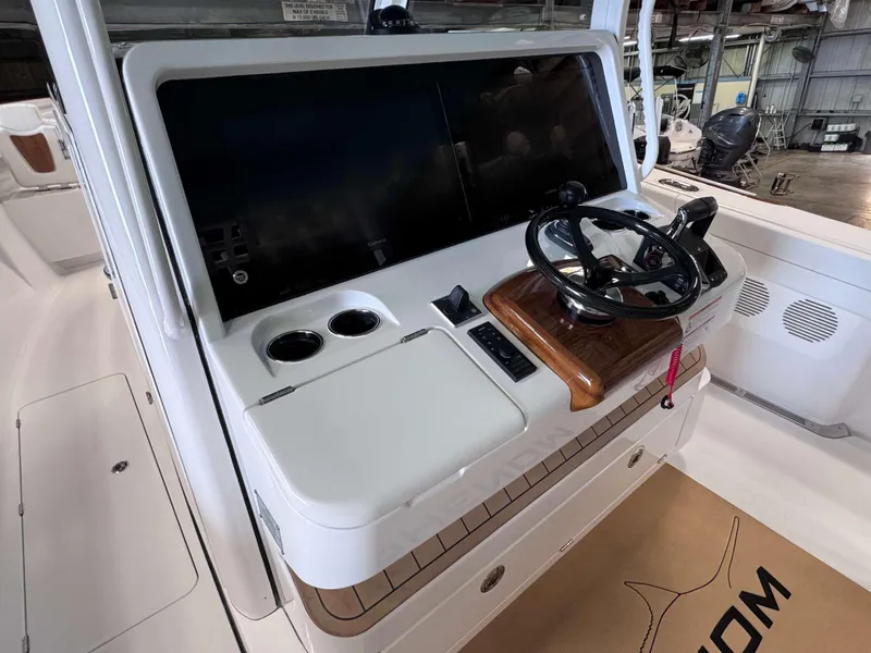 Slide: The Image of 2025 Phenom 37 CC boat helm with modern controls and sleek design. - 19