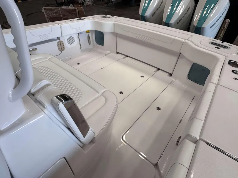 Slide: The Image of 2025 Phenom 37 CC boat interior with white seating and storage compartments. - 21