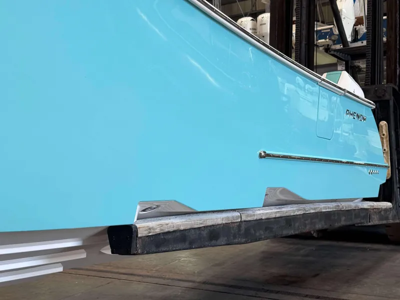 Slide: The Image of 2025 Phenom 37 CC boat in vibrant blue, displayed indoors. - 4