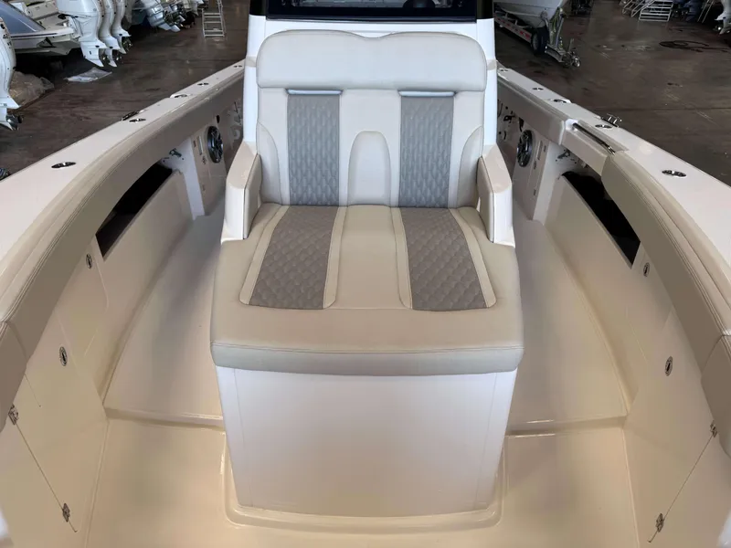 Slide: The Image of 2025 Solace 32 CS boat interior with cushioned seating in a showroom. - 10