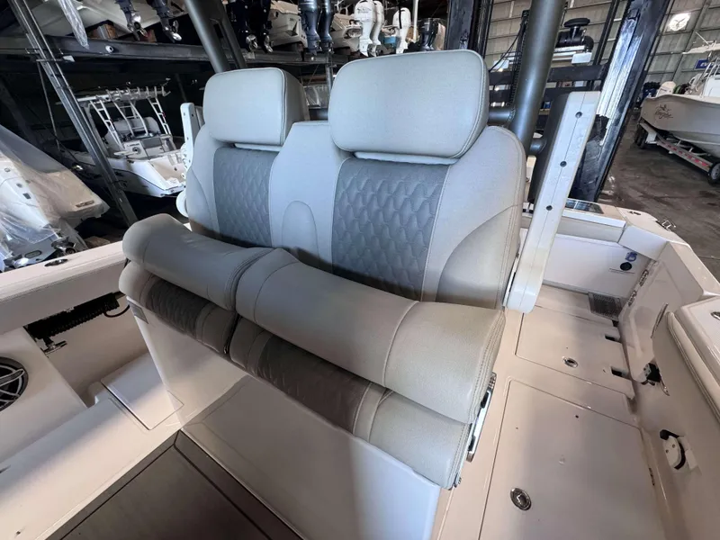 Slide: The Image of 2025 Solace 32 CS boat interior with plush seating in a storage facility. - 11