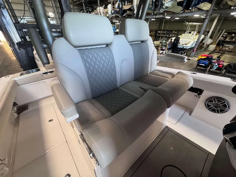 Slide: The Image of 2025 Solace 32 CS boat interior with plush seating in a showroom. - 12
