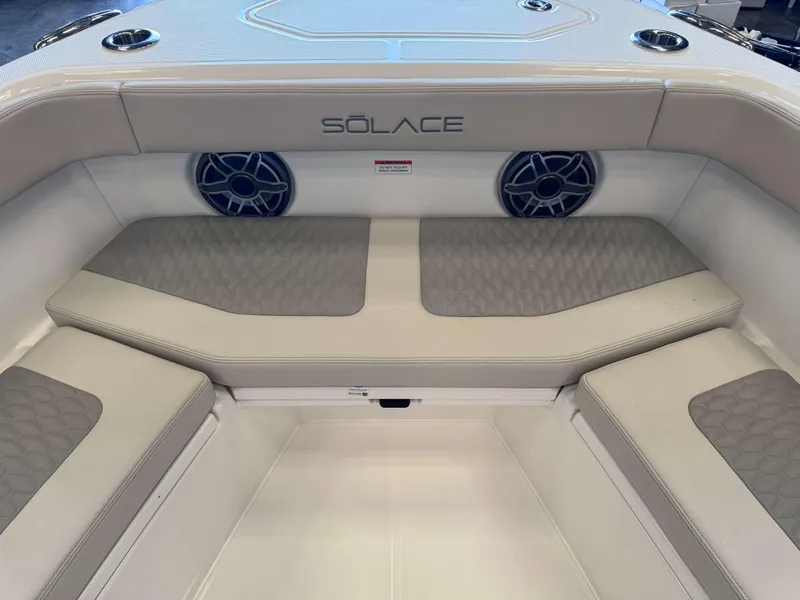 Slide: The Image of Interior seating of 2025 Solace 32 CS boat with speakers and cushioned seats. - 14