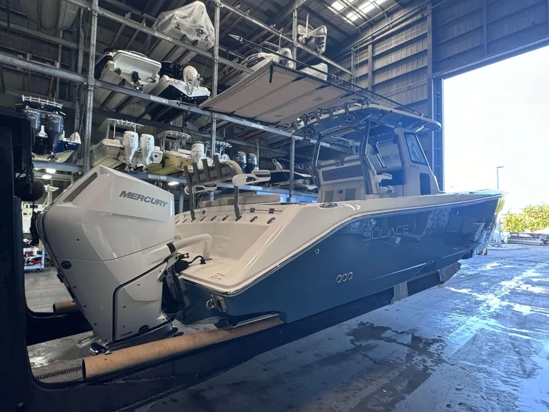 Slide: The Image of 2025 Solace 32 CS boat with Mercury engine in a warehouse setting. - 3