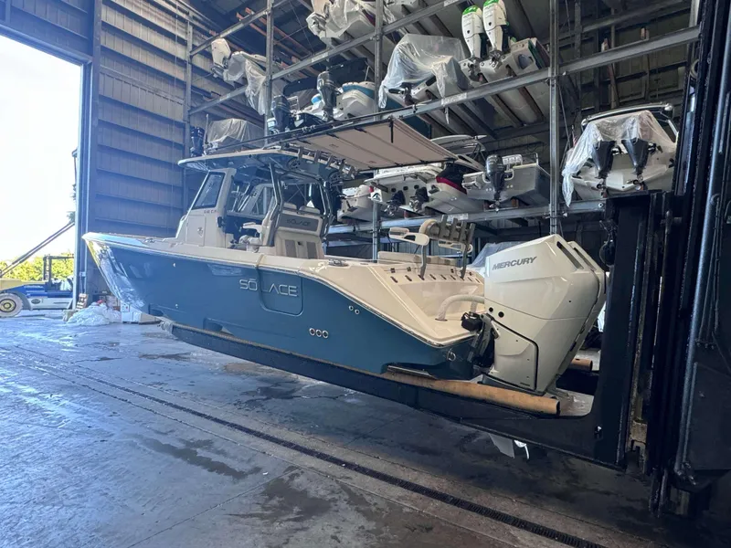 Slide: The Image of 2025 Solace 32 CS boat in storage facility with Mercury outboard engine. - 4