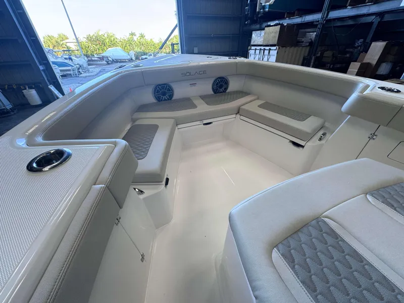 Slide: The Image of 2025 Solace 32 CS boat interior with cushioned seating and cup holders. - 6