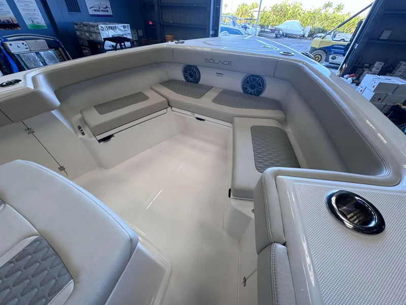 Slide: The Image of Interior of 2025 Solace 32 CS boat with cushioned seating and speakers. - 7