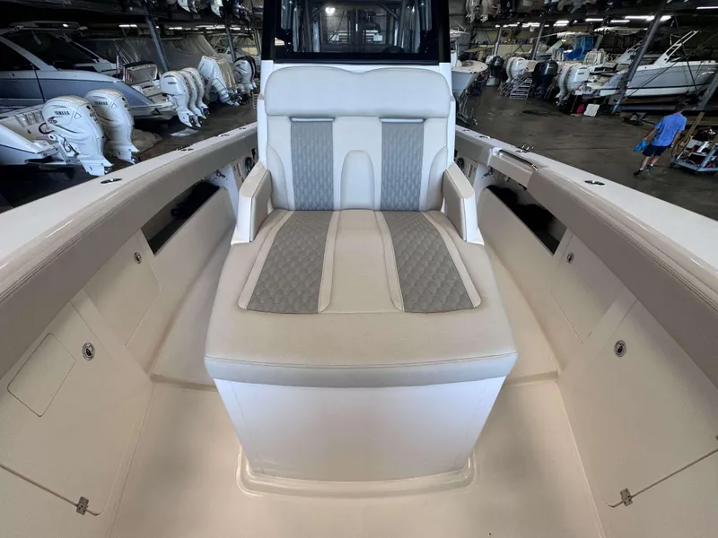 Slide: The Image of 2025 Solace 32 CS boat interior with cushioned seating in a marina setting. - 8