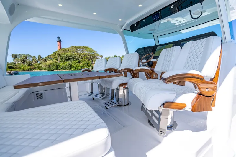 Slide: The Image of Luxurious interior of 2025 HCB 65 Estrella yacht with white seating and scenic lighthouse view. - 14
