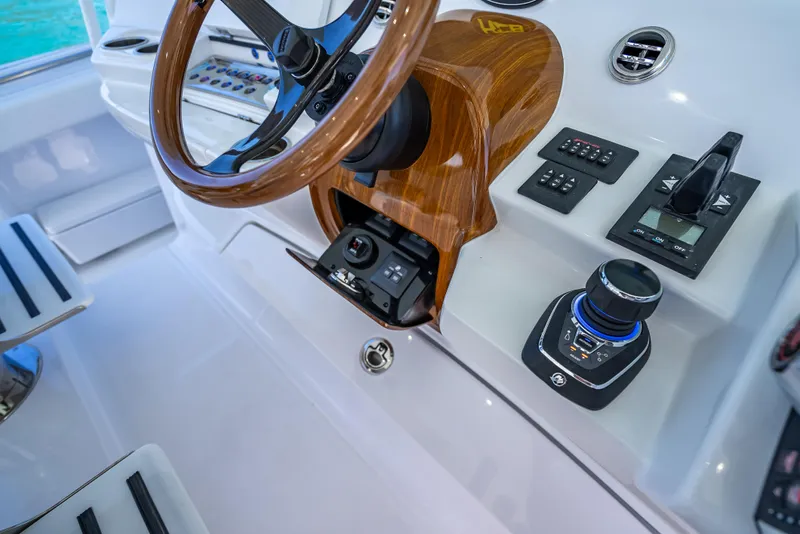 Slide: The Image of 2025 HCB 65 Estrella boat helm with wooden steering wheel and modern controls. - 15