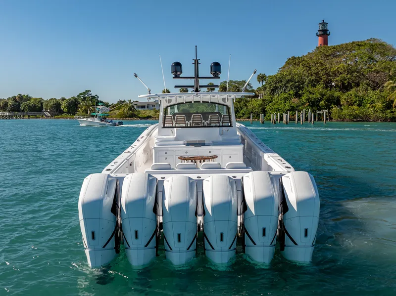 Slide: The Image of 2025 HCB 65 Estrella boat with six engines on clear water near a lighthouse. - 2