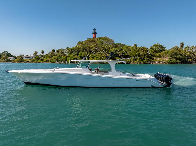 Slide: The Image of 2025 HCB 65 Estrella boat cruising on clear blue water near a lighthouse. - 4