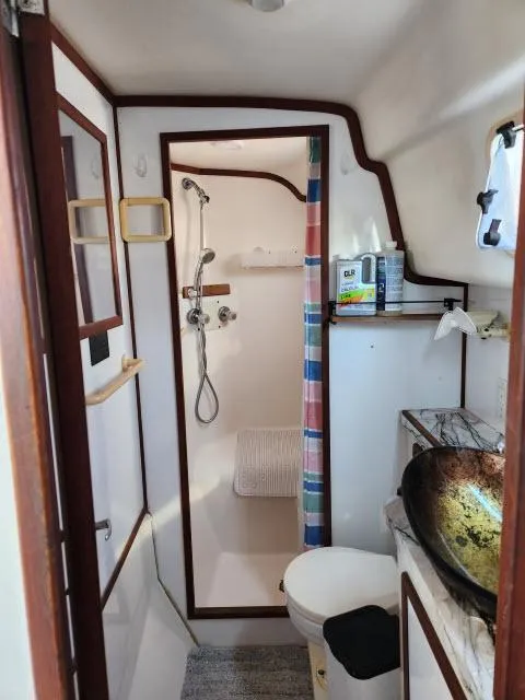 Slide: The Image of 1992 Endeavourcat 30 catamaran bathroom with shower, sink, and colorful curtain. - 16