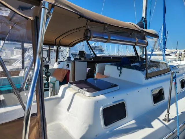 Slide: The Image of 1992 Endeavourcat 30 catamaran with tan canopy, docked in a marina under clear blue skies. - 18