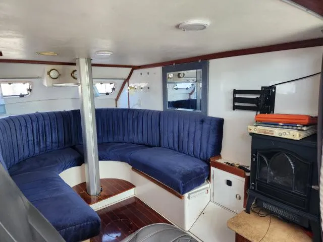 Slide: The Image of Cozy interior of 1992 Endeavourcat 30 catamaran with blue seating and wood accents. - 2