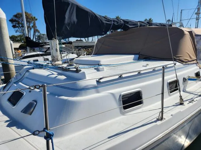 Slide: The Image of 1992 Endeavour Catamaran Endeavourcat 30 docked, featuring sleek white design and covered sail. - 29