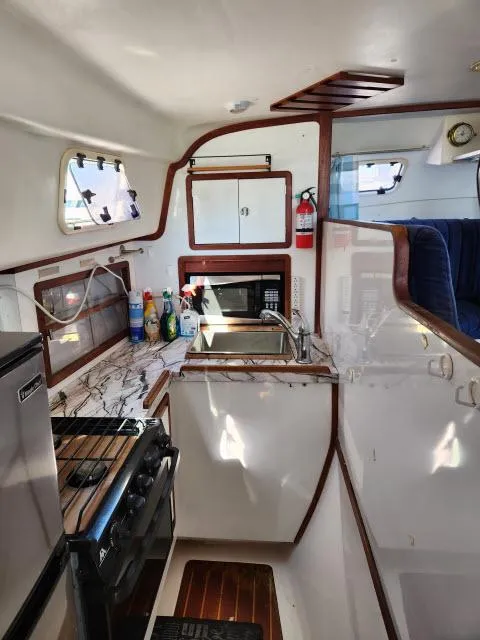 Slide: The Image of Interior of 1992 Endeavourcat 30 catamaran kitchen with stove, sink, and storage. - 4