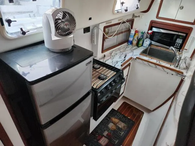 Slide: The Image of 1992 Endeavourcat 30 catamaran kitchen with fridge, stove, and microwave. - 5