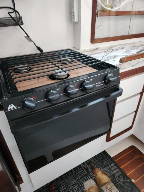Slide: The Image of 1992 Endeavour Catamaran Endeavourcat 30 kitchen with stove and wooden cabinetry. - 6