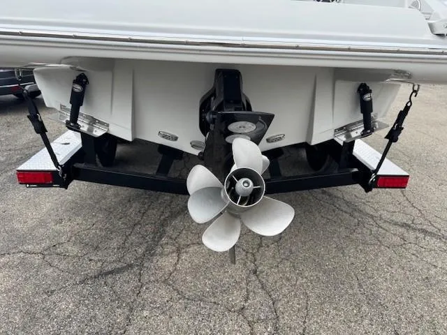 Slide: The Image of 2025 Crownline 280 SS boat stern with propeller and trailer on pavement. - 4