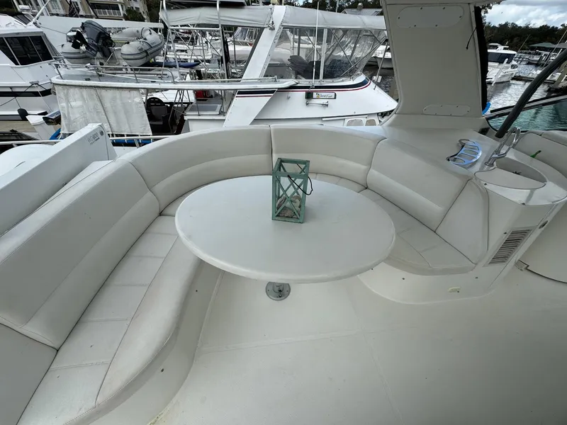 Slide: The Image of 2006 Carver 56 Voyager yacht with white seating and table on deck. - 15