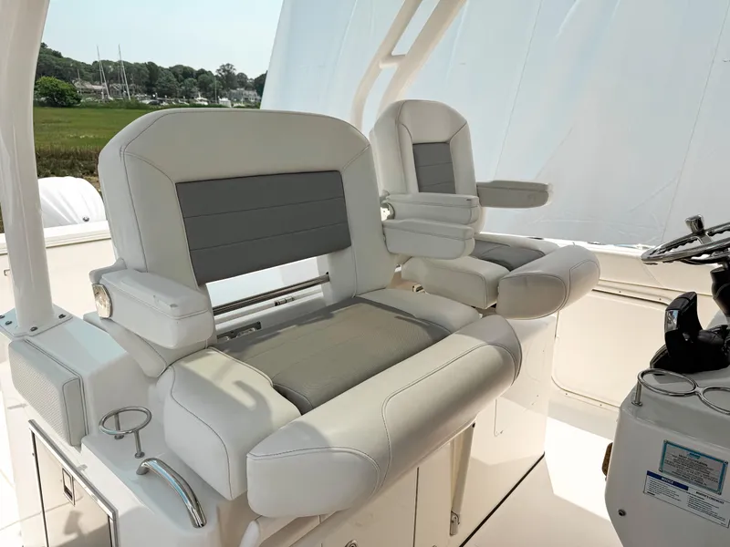 Slide: The Image of 2022 Pursuit S 328 Sport boat seats, featuring luxurious white and gray upholstery. - 19