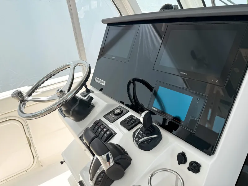 Slide: The Image of Control panel of 2022 Pursuit S 328 Sport boat with steering wheel and digital displays. - 21