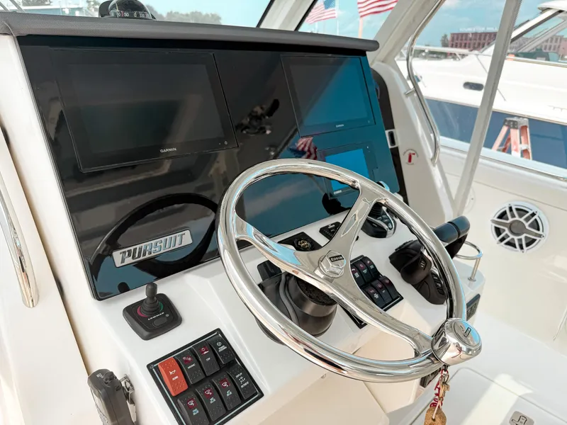 Slide: The Image of 2022 Pursuit S 328 Sport boat helm with steering wheel and control panel. - 22
