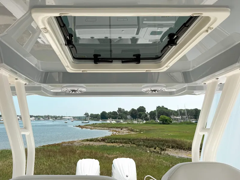 Slide: The Image of 2022 Pursuit S 328 Sport boat interior with sunroof, overlooking scenic waterfront. - 24