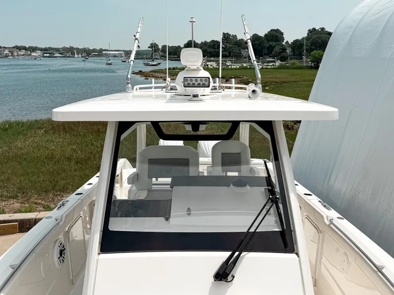 Slide: The Image of 2022 Pursuit S 328 Sport boat docked by a scenic waterfront. - 26