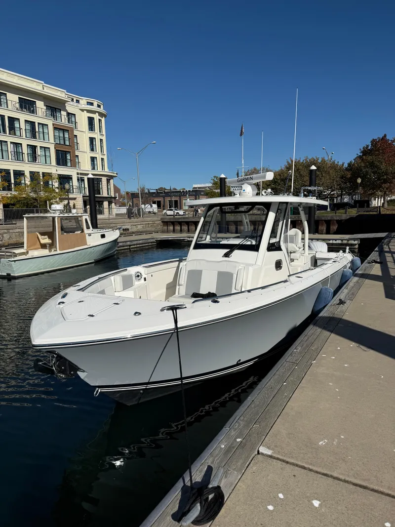 Slide: The Image of 2022 Pursuit S328 boat docked in a marina under clear blue skies. - 4