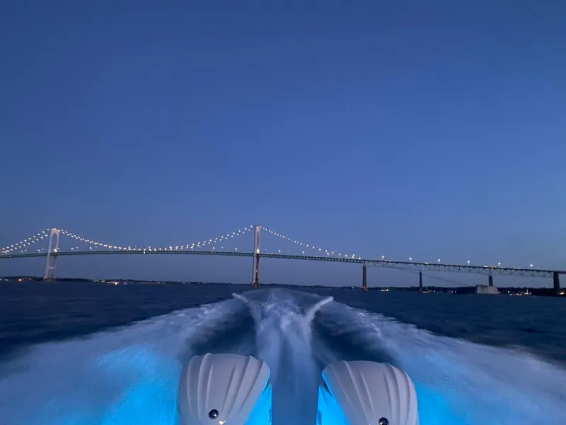 Slide: The Image of Pursuit S328 boat cruising under illuminated bridge at dusk, 2022 model. - 46