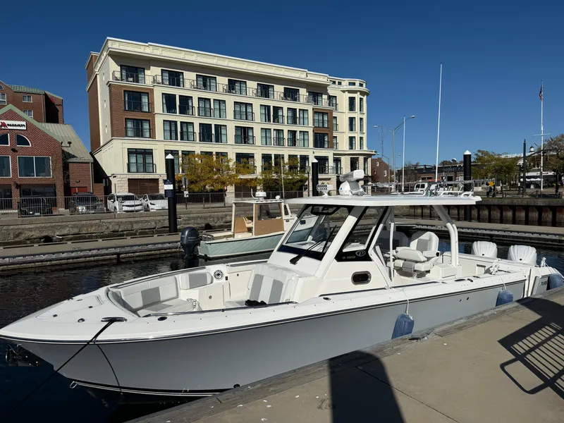 Slide: The Image of 2022 Pursuit S328 boat docked near modern waterfront building. - 5