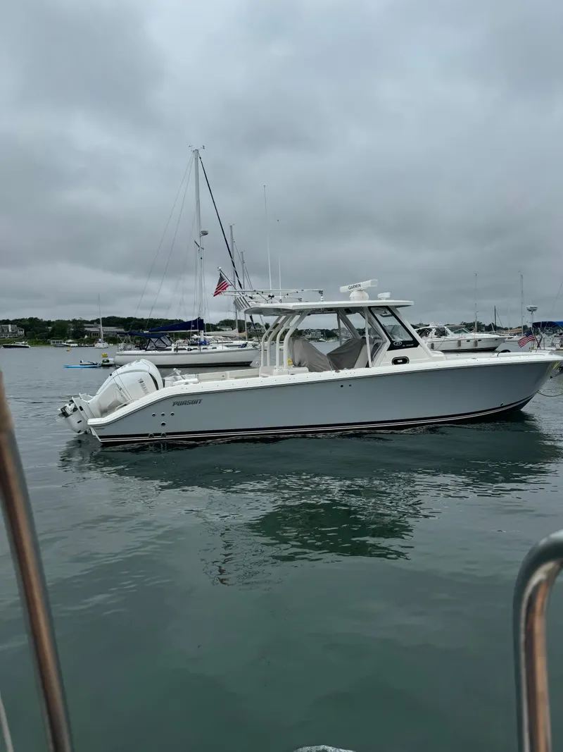 Slide: The Image of 2022 Pursuit S328 boat on calm water under cloudy skies. - 6