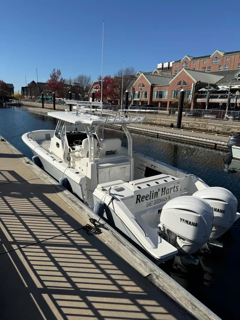 Slide: The Image of 2022 Pursuit S328 boat docked in a marina with Yamaha engines. - 7