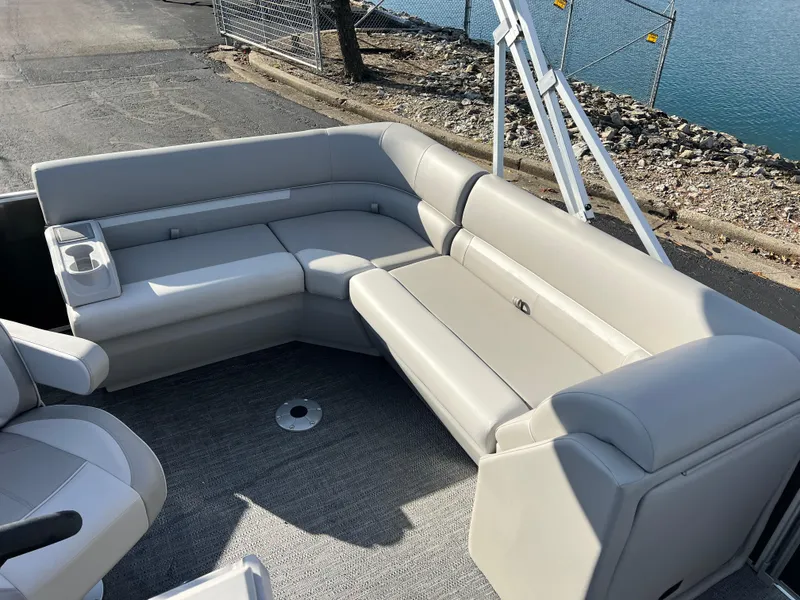 Slide: The Image of 2025 Godfrey Xperience 1880 CX boat with spacious gray seating area by the water. - 11