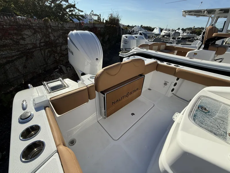 Slide: The Image of 2025 NauticStar 242OS boat interior with Yamaha engine, featuring tan and white seating. - 10