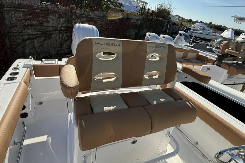 Slide: The Image of 2025 NauticStar 242OS boat interior with tan seating and sleek design. - 14