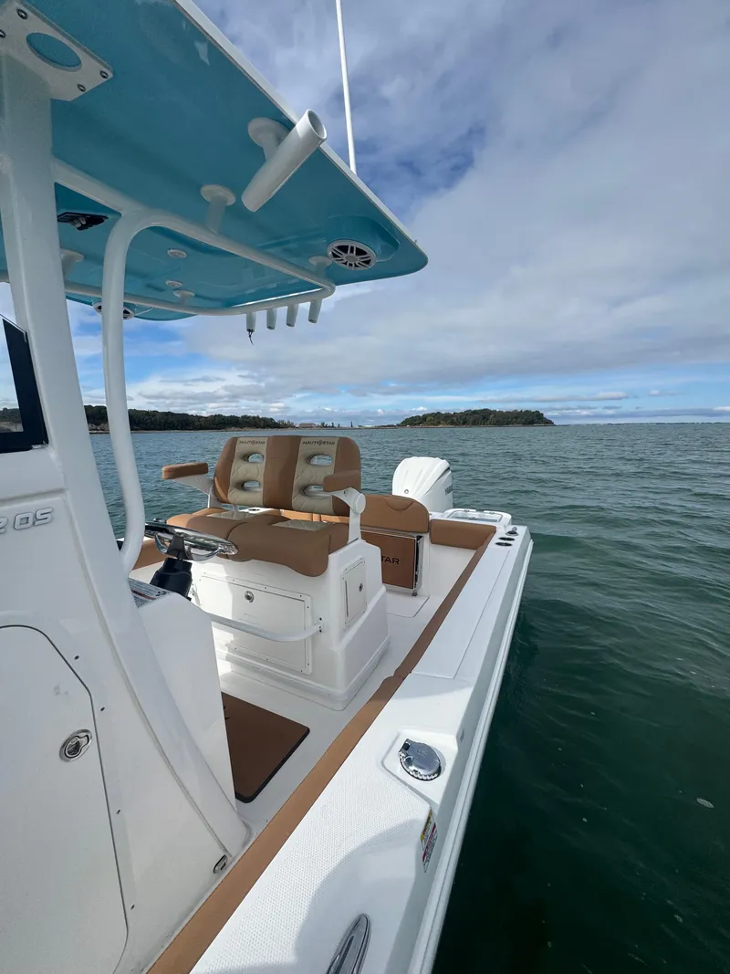 Slide: The Image of 2025 NauticStar 242OS boat on open water, featuring sleek design and comfortable seating. - 19