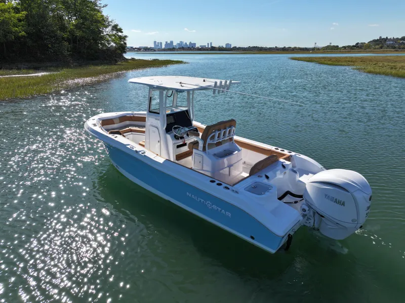Slide: The Image of 2025 NauticStar 242OS boat on serene water with city skyline in background. - 4