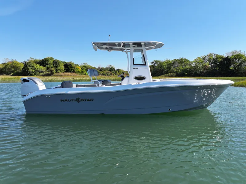 Slide: The Image of 2025 NauticStar 242OS boat on calm water, clear sky background. - 7