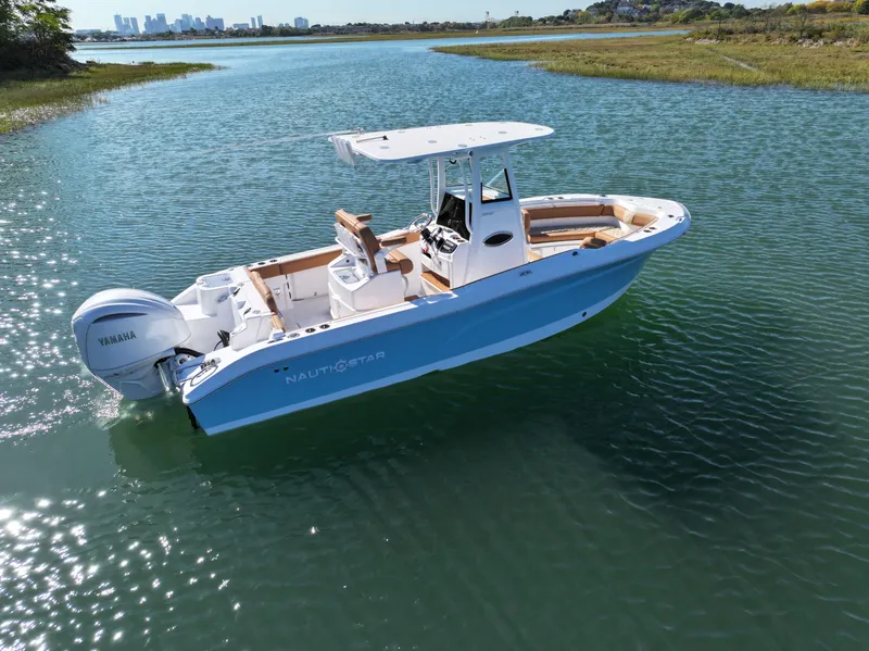 Slide: The Image of 2025 NauticStar 242OS boat on calm water with Yamaha engine. - 8
