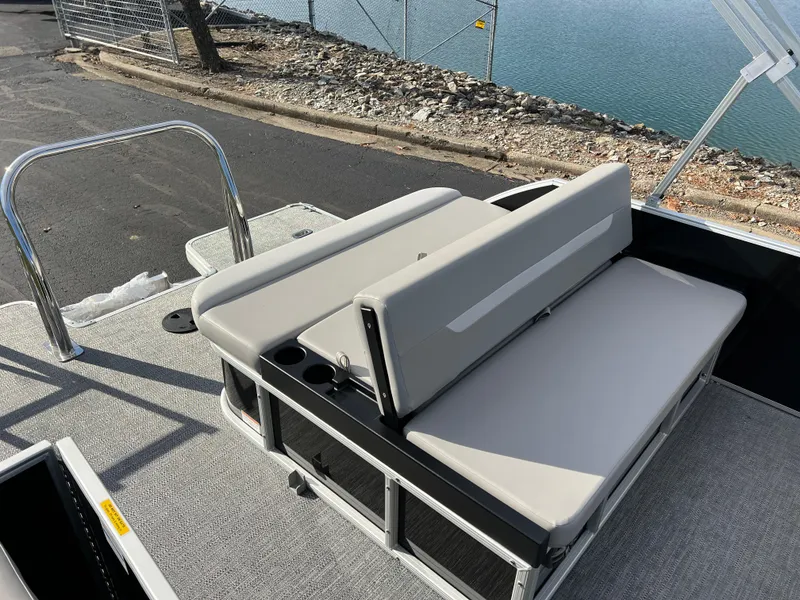 Slide: The Image of 2025 Godfrey XPERIENCE 2286 SFLC boat with gray seating, docked by the water. - 12