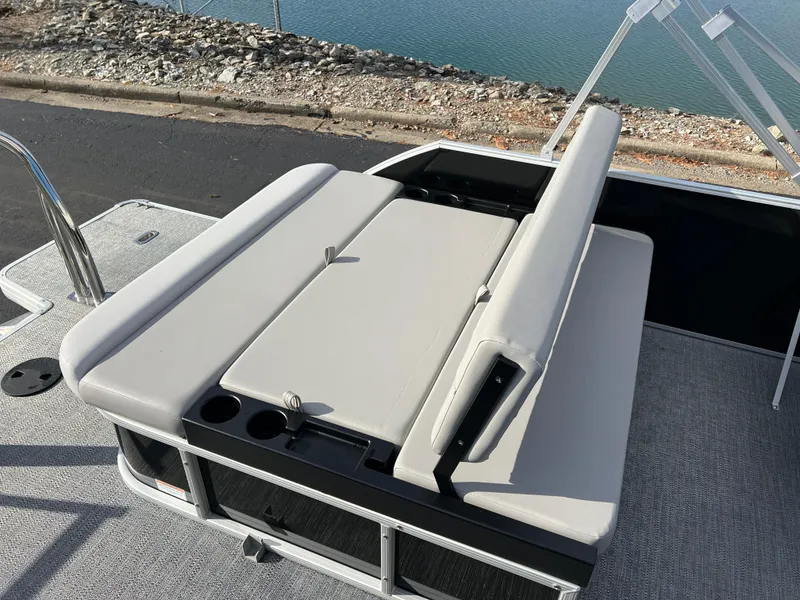 Slide: The Image of 2025 Godfrey XPERIENCE 2286 SFLC boat seating area with cup holders, near water. - 13