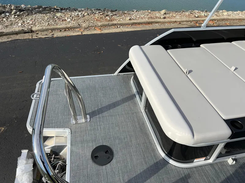 Slide: The Image of 2025 Godfrey XPERIENCE 2286 SFLC boat deck with seating and railing by the water. - 15