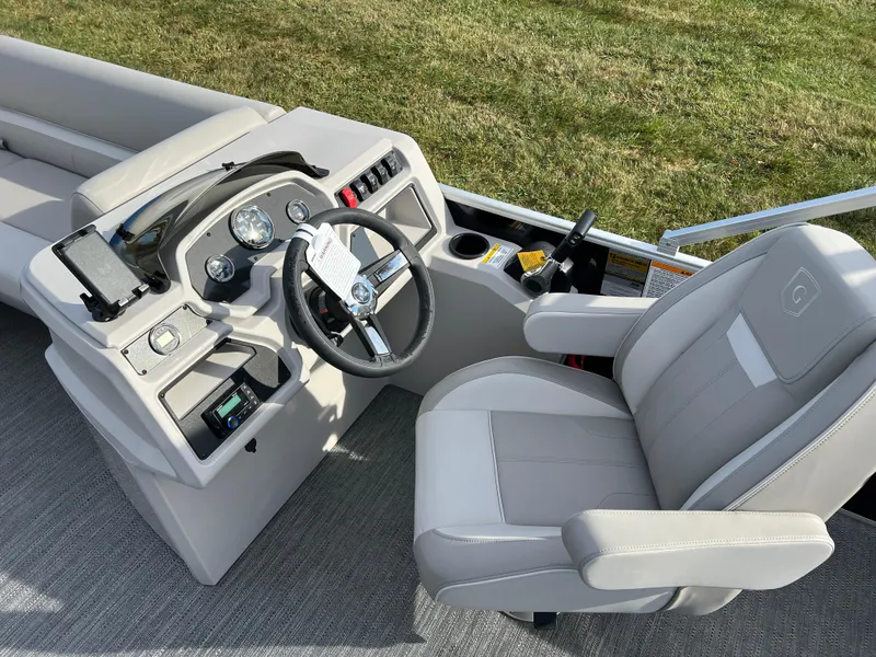 Slide: The Image of 2025 Godfrey XPERIENCE 2286 SFLC boat cockpit with steering wheel and comfortable seating. - 18