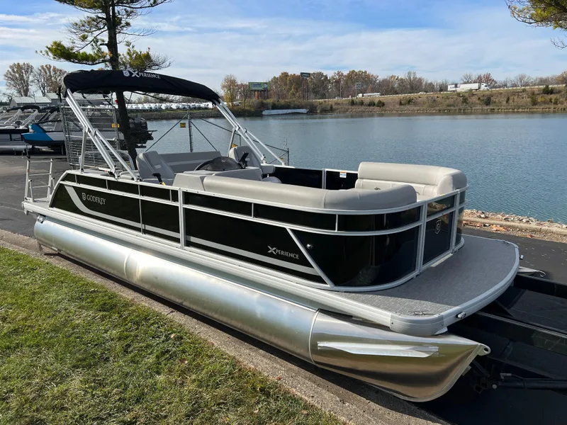 Slide: The Image of 2025 Godfrey XPERIENCE 2286 SFLC pontoon boat docked by a serene lake. - 2