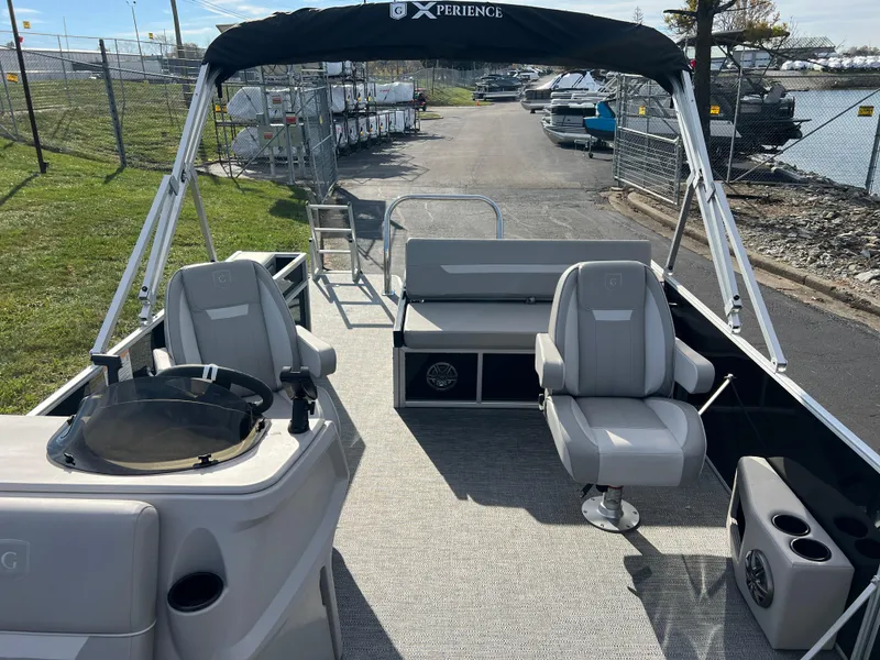 Slide: The Image of 2025 Godfrey XPERIENCE 2286 SFLC pontoon boat with seating and helm, docked near water. - 9