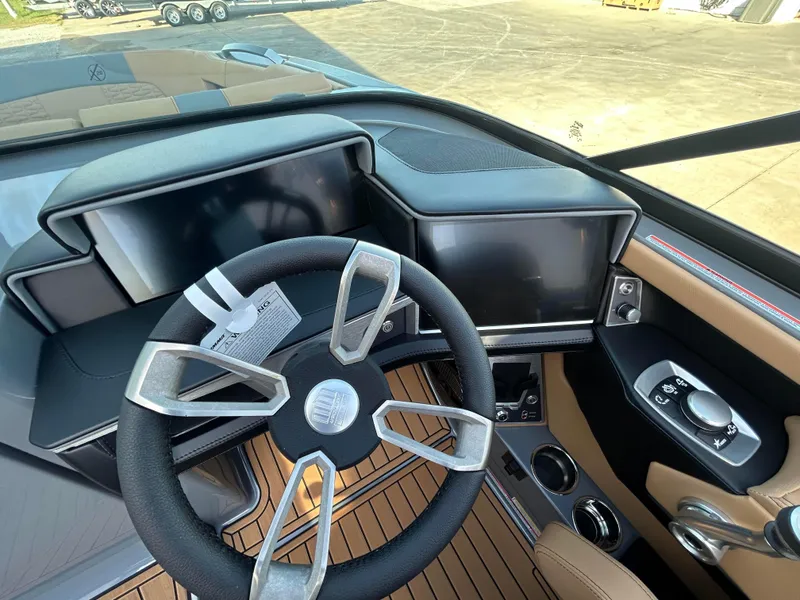 Slide: The Image of 2025 MasterCraft X26 boat dashboard with modern steering wheel and digital displays. - 12