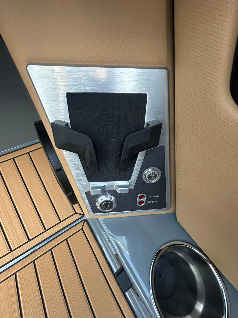 Slide: The Image of 2025 MasterCraft X26 boat interior with cup holder and control panel. - 13